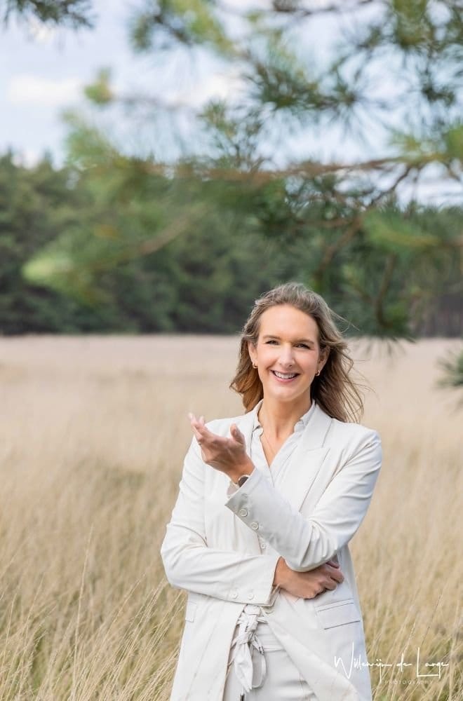 34 Vrouw reikt haar hand uit in de natuur, symbool voor loslaten en vertrouwen in je eigen pad.